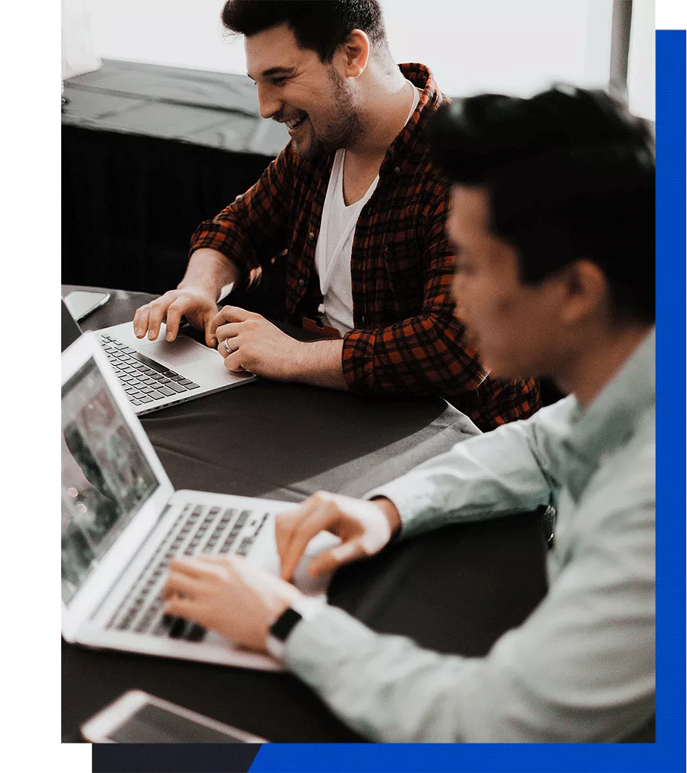 Two men working on laptops
