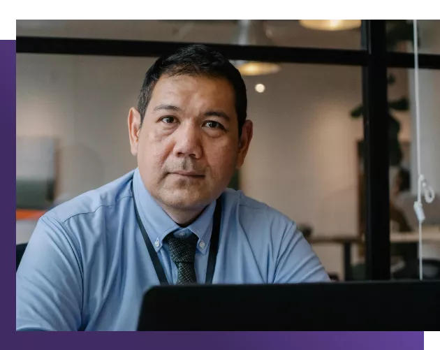 Male sitting at desk looking toward viewer