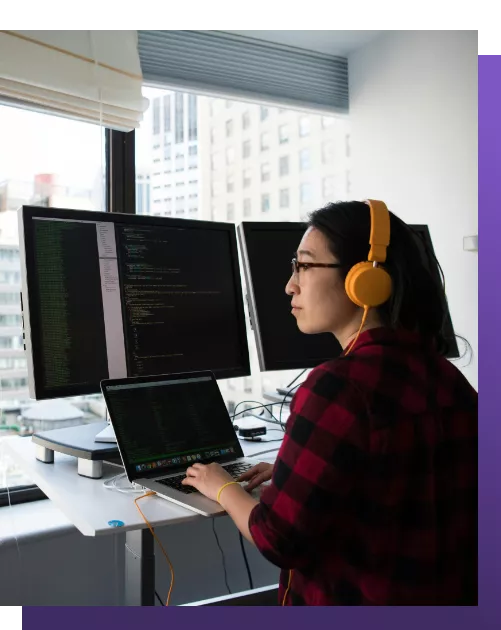 Young girl working with computer at multiple screens